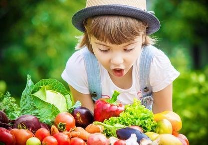 dziewczynka z zachwytem patrzy na warzywa