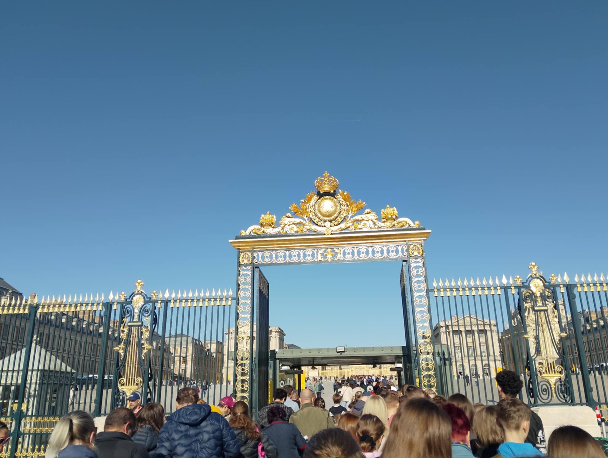 Odwiedzający przed bramą Pałacu w Wersalu